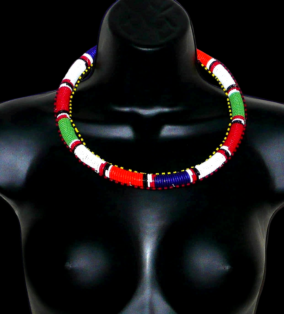 Collier africain tribal à motifs traditionnels Massai composé de perles de rocaille principalement rouges, vertes, blanches, bleu foncé et orange tissées et enroulées autour d'un tube.