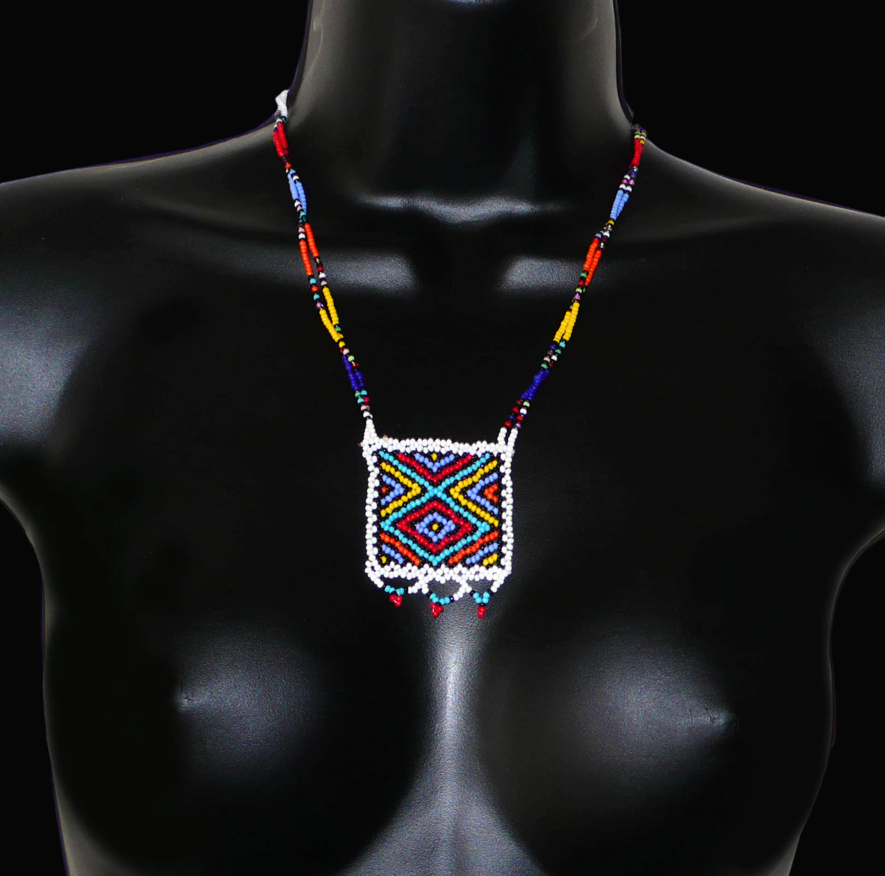 Collier africain zoulou en perles de rocaille blanches et multicolores agrémenté d'un pendentif carré à motifs ethniques traditionnels.