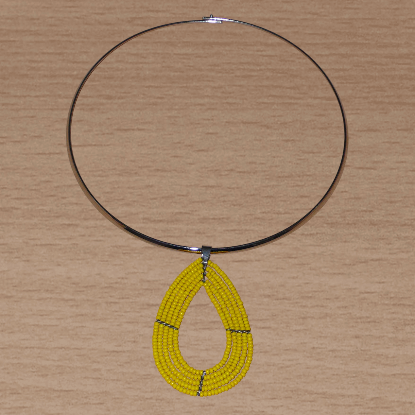 Collier jaune composé d'un ras de cou en laiton orné d'un pendentif multi-rangs fait de perles de rocaille montées en forme de goutte.