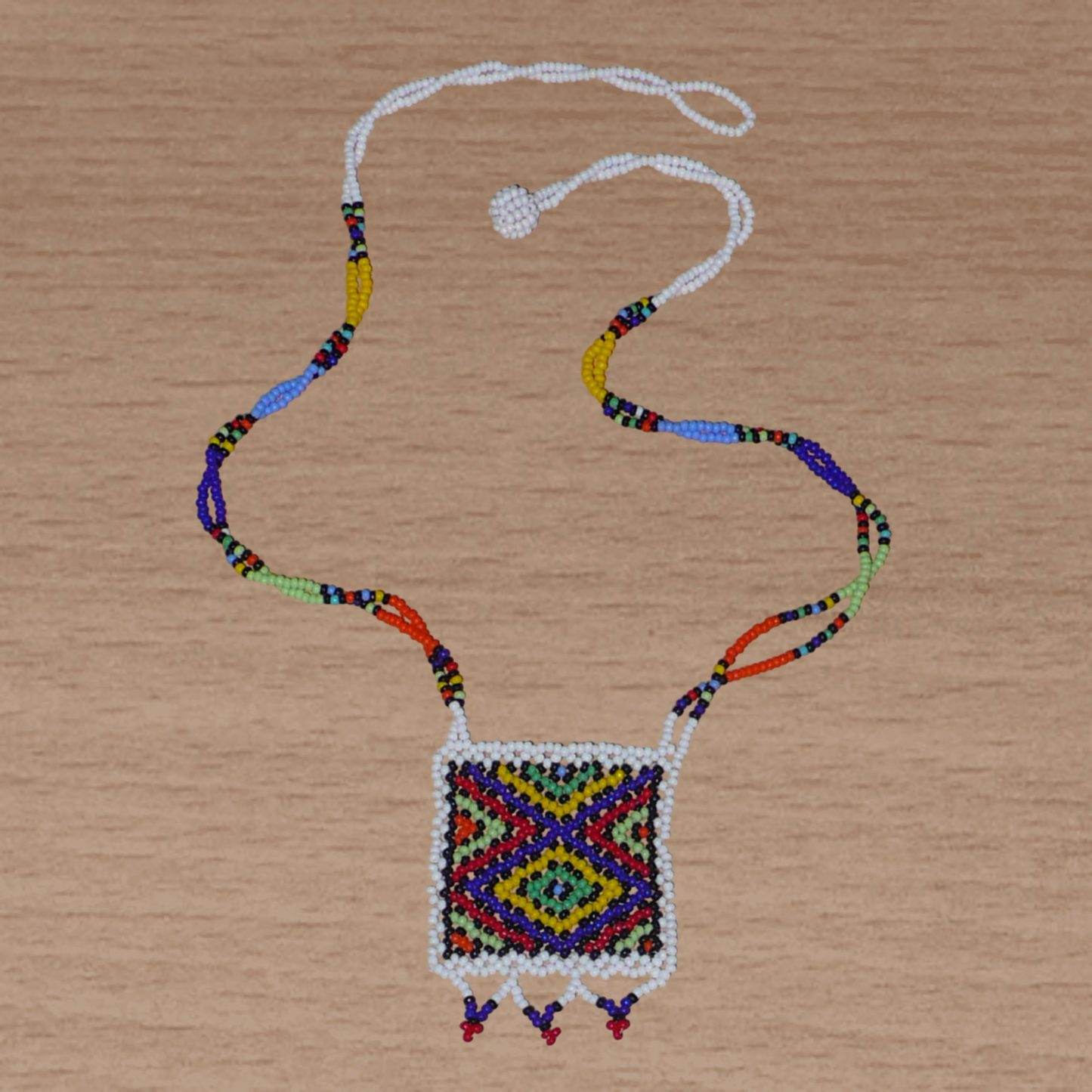 Collier africain zoulou avec pendentif ; fabriqué en Afrique du Sud, il se compose d'un tissage traditionnel de perles de rocaille blanches et multicolores.