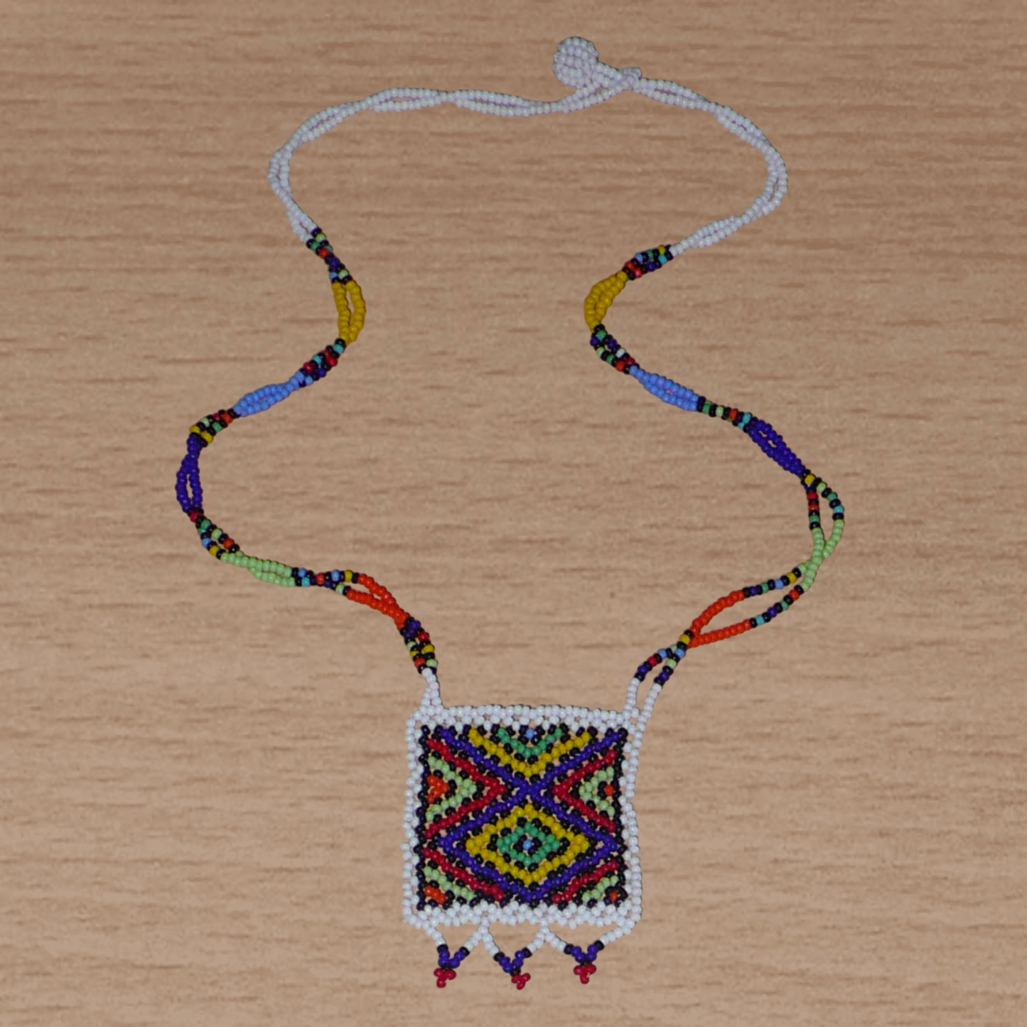 Collier africain zoulou avec pendentif ; fabriqué en Afrique du Sud, il se compose d'un tissage traditionnel de perles de rocaille blanches et multicolores.
