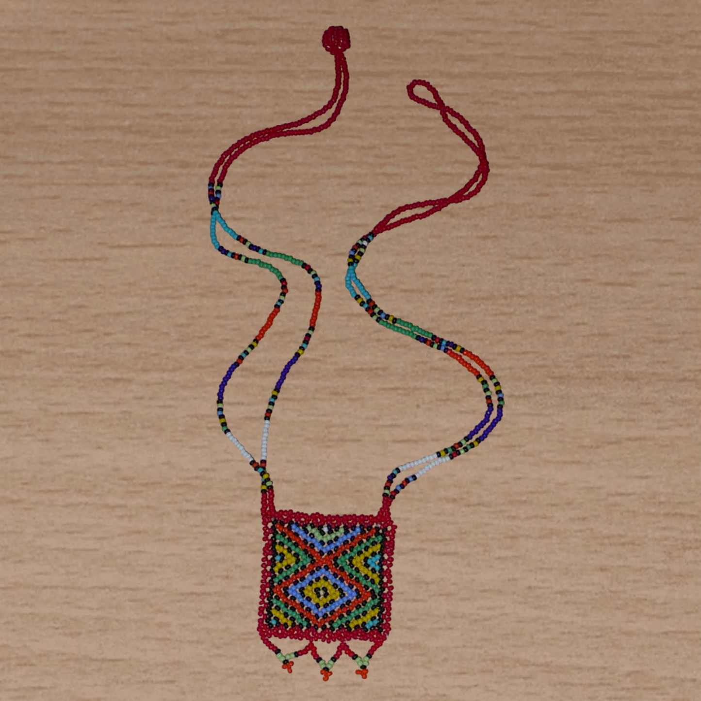 Collier africain "Zulu Love Letter" avec pendentif orné de motifs ethniques ; il se compose d'un tissage de perles de rocaille rouges et multicolores.
