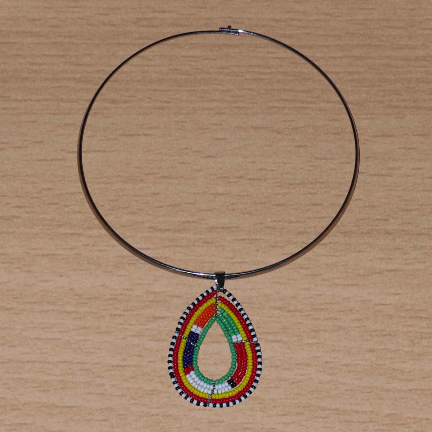 Collier africain Massai composé d'un ras de cou en laiton agrémenté d'un pendentif fait de perles de rocaille vertes et multicolores enfilées sur six rangées de fils de fer montés en forme de goutte.