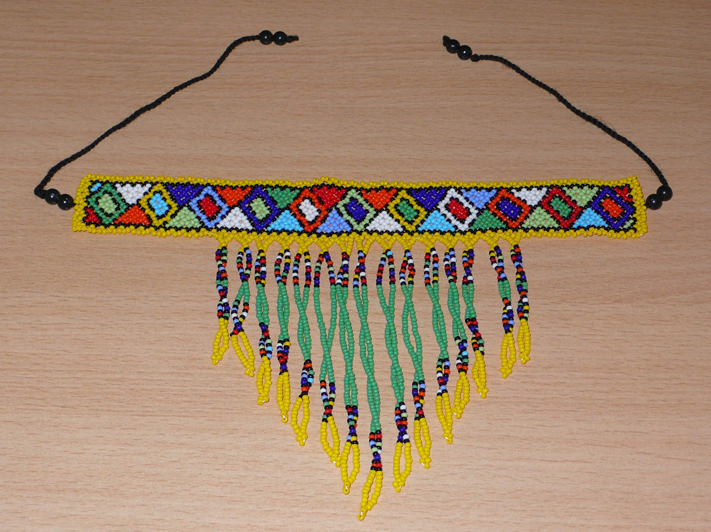 Collier ras de cou sud-africain à franges perlées et à motifs ethniques zoulous composé de perles de rocaille vertes, jaunes et multicolores.