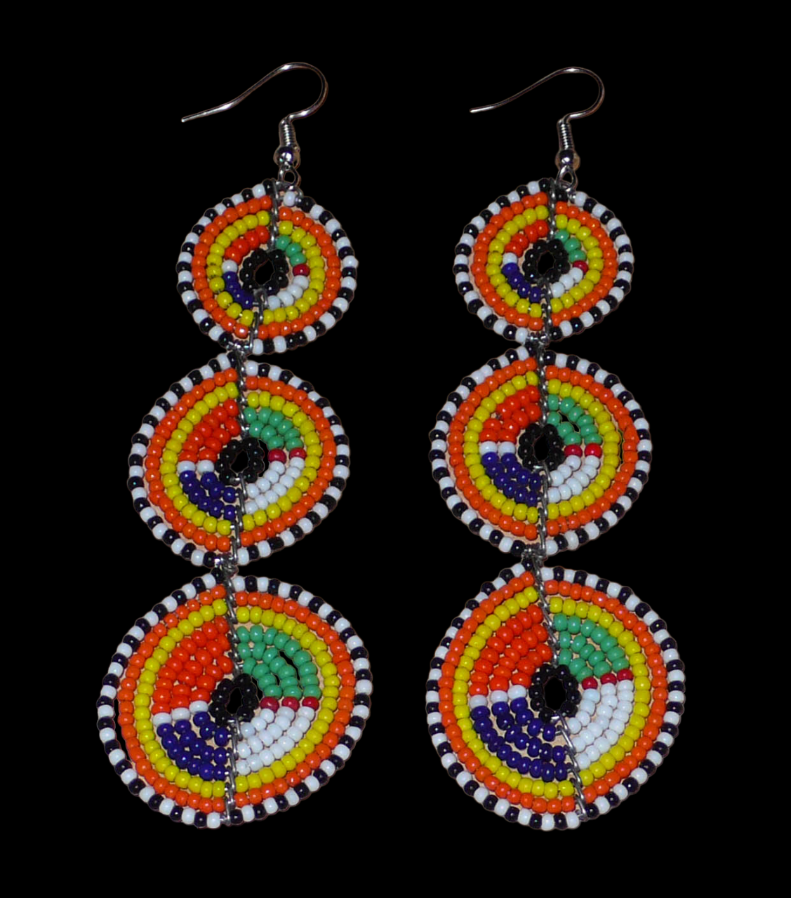 Longues boucles d'oreilles ethniques afro chic composées de perles de rocaille multicolores montées en trois cercles superposés. Elles mesurent 10,5 cm de long et 3 cm de large.