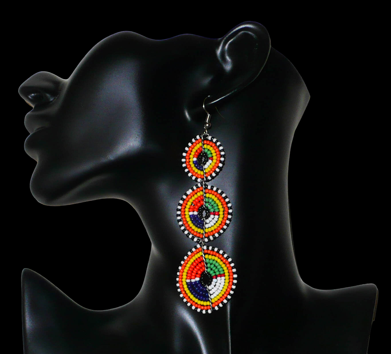 Longues boucles d'oreilles ethniques afro chic composées de perles de rocaille multicolores montées en trois cercles superposés. Elles mesurent 10,5 cm de long et 3 cm de large.
