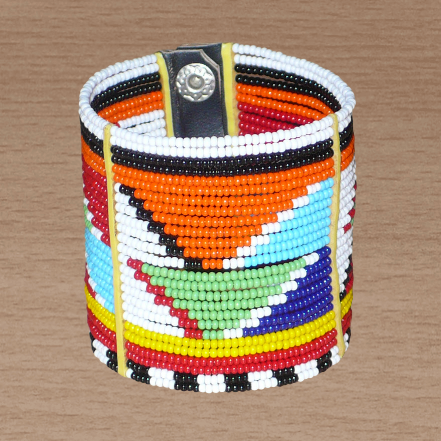 Bracelet africain Massai composé de vingt-six rangées de perles multicolores aux motifs géométriques enfilées sur des fils de fer fixés sur des charnières en plastique. Le bracelet se ferme avec des boutons pressions.