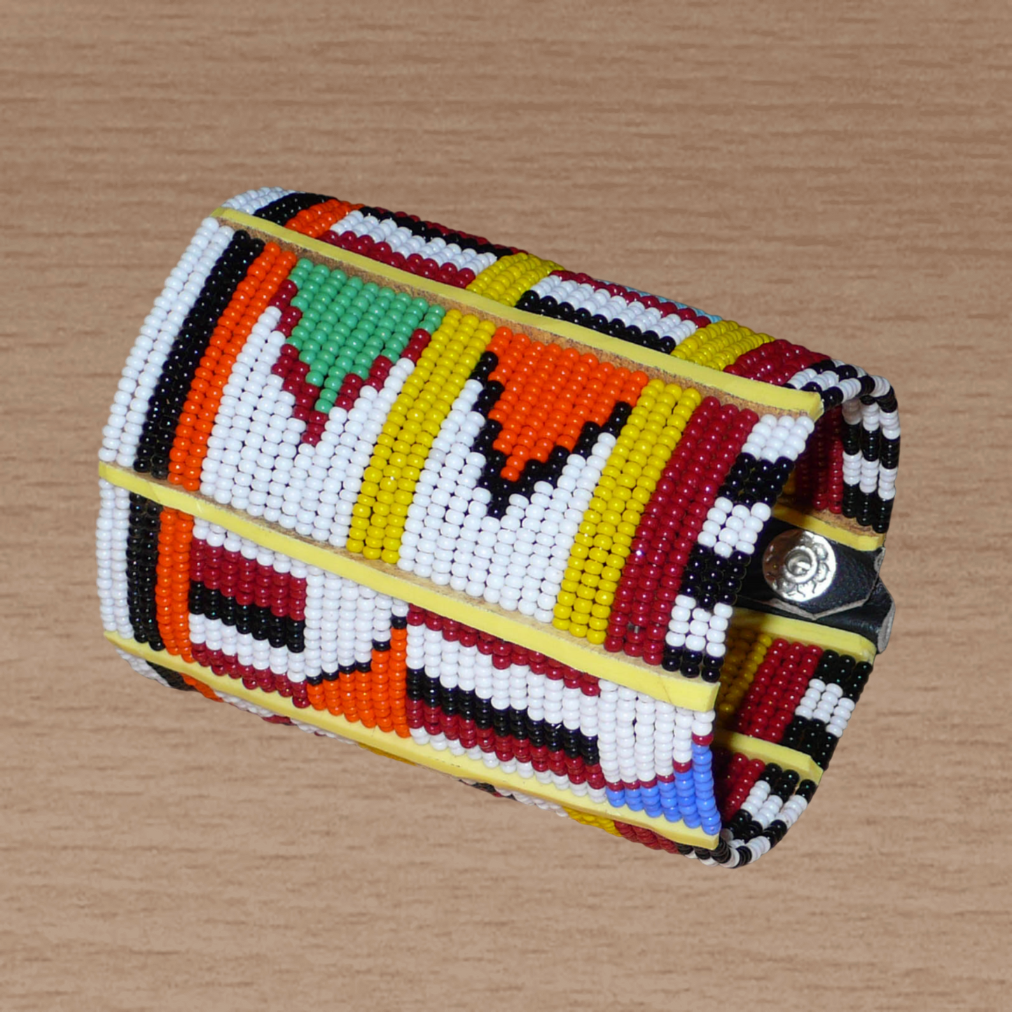 Manchette africaine multi-rangs à motifs ethniques traditionnels Massai composée de trente-six rangées de perles de rocaille multicolores glissées sur des fils de fer fixés sur des charnières en plastique jaune.