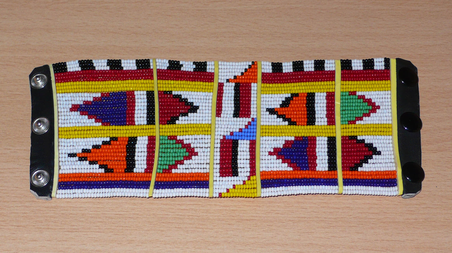 Manchette africaine perlée à motifs ethniques Massai composée de plusieurs rangs de perles de rocaille multicolores glissées sur des fils de fer fixés sur des charnières en plastique.