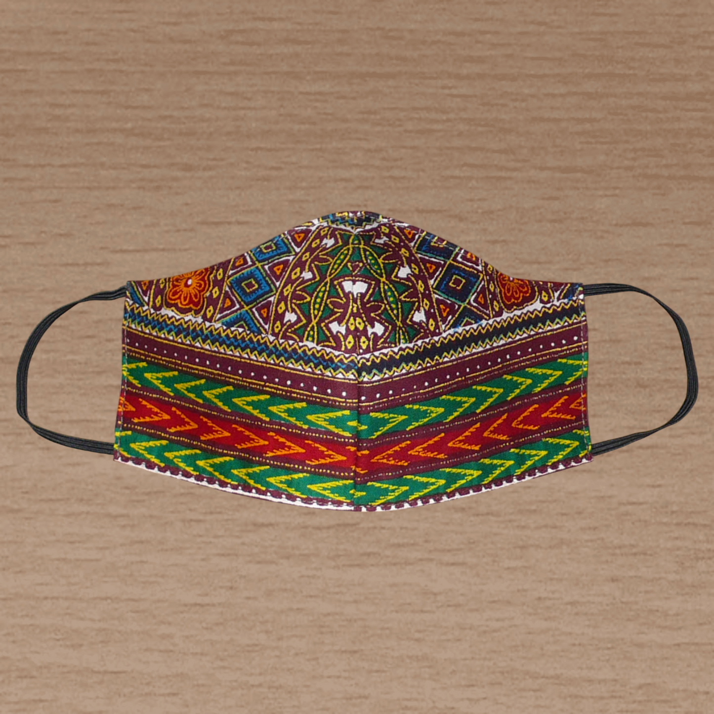Masque textile à la coupe ajustée en tissu africain en coton imprimé de motifs ethniques multicolores ; il se porte avec des élastiques. En vue d'une utilisation eco-friendly, ce masque est lavable et réutilisable. D'allure afro chic, ce masque mesure 21 cm de long, et 40 cm en comptant les élastiques ; il a une hauteur de 12 cm (du haut du nez jusqu'au menton) et une largeur sur les côtés de 7 cm. Unisexe, il peut être porté par une femme ou par un homme.