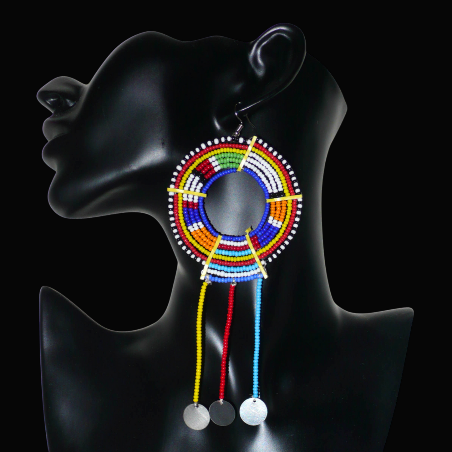 Mono boucle d'oreille africaine Massai à porter sur une seule oreille pour créer un effet d'asymétrie visuelle : elle se compose de perles de rocaille bleues et multicolores enfilées sur des fils de fer montés en cercles fixés sur des charnières en plastique recyclé jaune ; il se prolonge de franges perlées ornées de disques en métal. Surdimensionnée, cette mono boucle d'oreille à l'allure exotique mesure 15 cm de long.