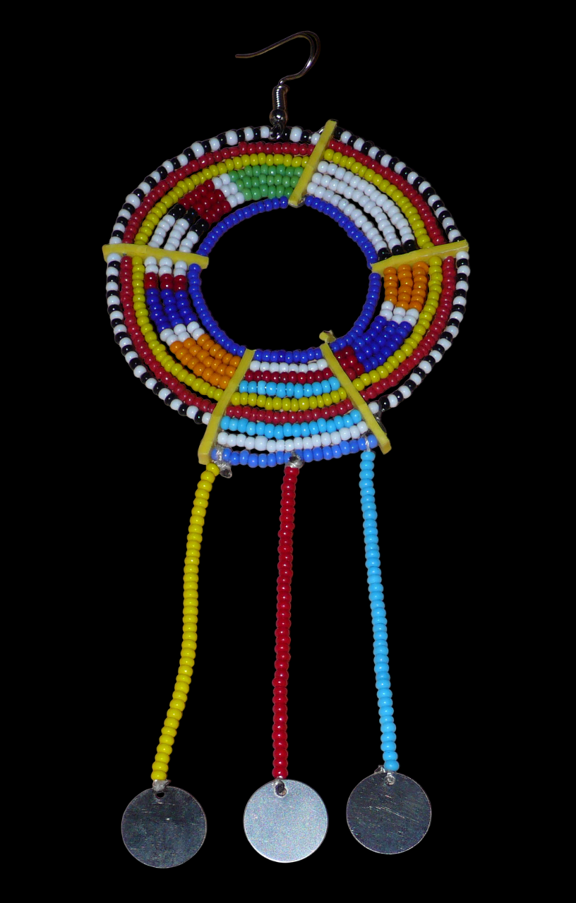 Mono boucle d'oreille africaine Massai à porter sur une seule oreille pour créer un effet d'asymétrie visuelle : elle se compose de perles de rocaille bleues et multicolores enfilées sur des fils de fer montés en cercles fixés sur des charnières en plastique recyclé jaune ; il se prolonge de franges perlées ornées de disques en métal. Surdimensionnée, cette mono boucle d'oreille à l'allure exotique mesure 15 cm de long.