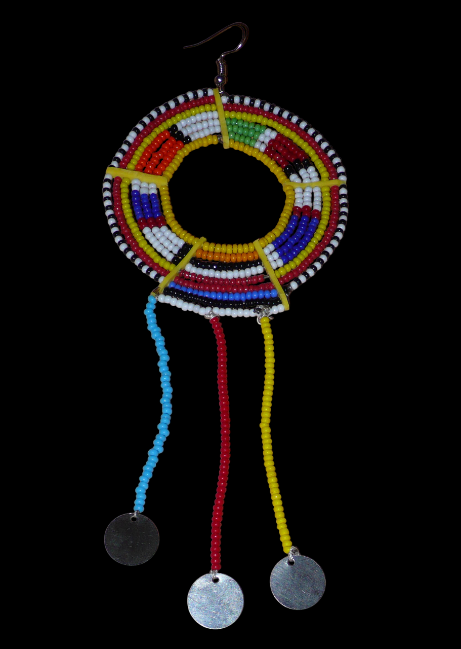 Mono boucle d'oreille à franges fabriquée au Kenya dans la tradition ethnique Massai. À porter sur une seule oreille pour un effet visuel asymétrique, ce bijou se compose de perles de rocaille multicolores glissées sur des fils de fer montés en cercles fixés sur des charnières en plastique recyclé jaune ; il se prolonge de franges perlées ornées de disques en métal. Surdimensionnée, elle mesure 16.5 cm de long et 6.5 cm de large, et se porte sur une oreille percée.