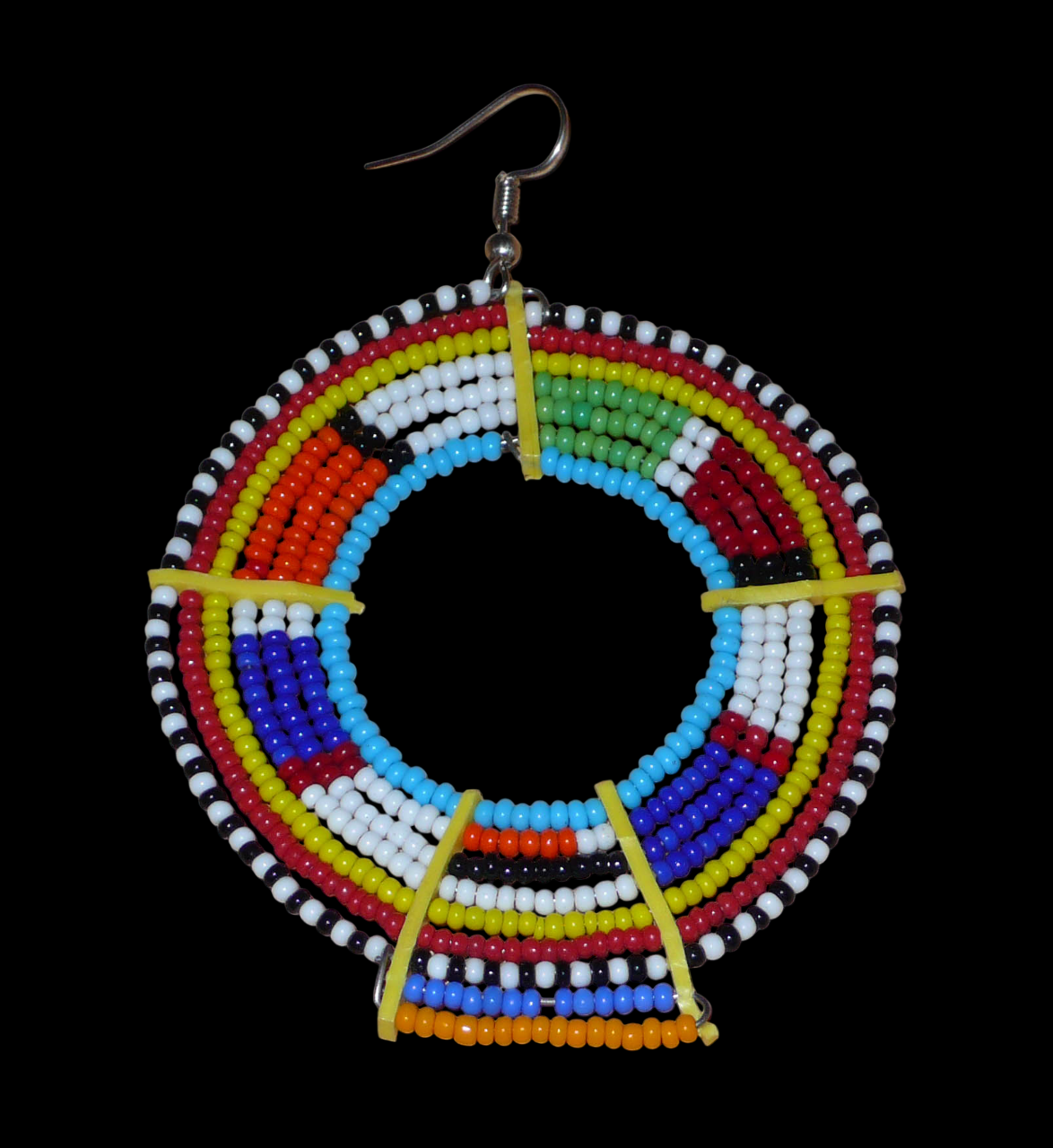 Ajoutez une touche ultra colorée à votre look avec cette mono boucle africaine Massai, à porter sur une seule oreille pour un effet visuel asymétrique ! De fabrication traditionnelle kenyane, ce bijou artisanal se compose de perles de rocaille bleues et multicolores glissées sur des fils de fer montés en cercles et fixés sur des charnières en plastique recyclé jaune. Surdimensionnée, elle mesure 8.5 cm de long et 6 cm de large, et se porte avec un crochet sur une oreille percée.