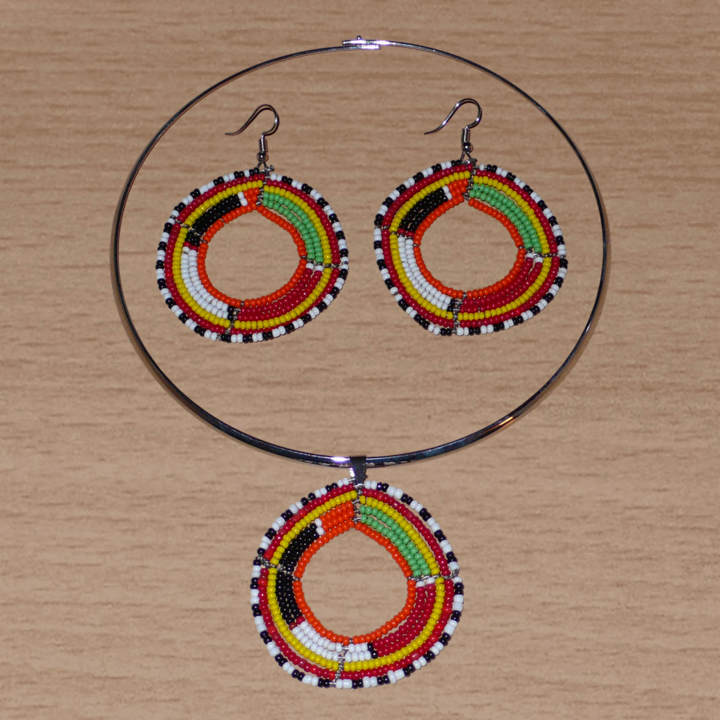 Parure de bijoux africains Massai composée d'un collier ras de cou en laiton orné d'un médaillon fait de perles de rocaille multicolores, et d'une paire de boucles d'oreilles assorties.