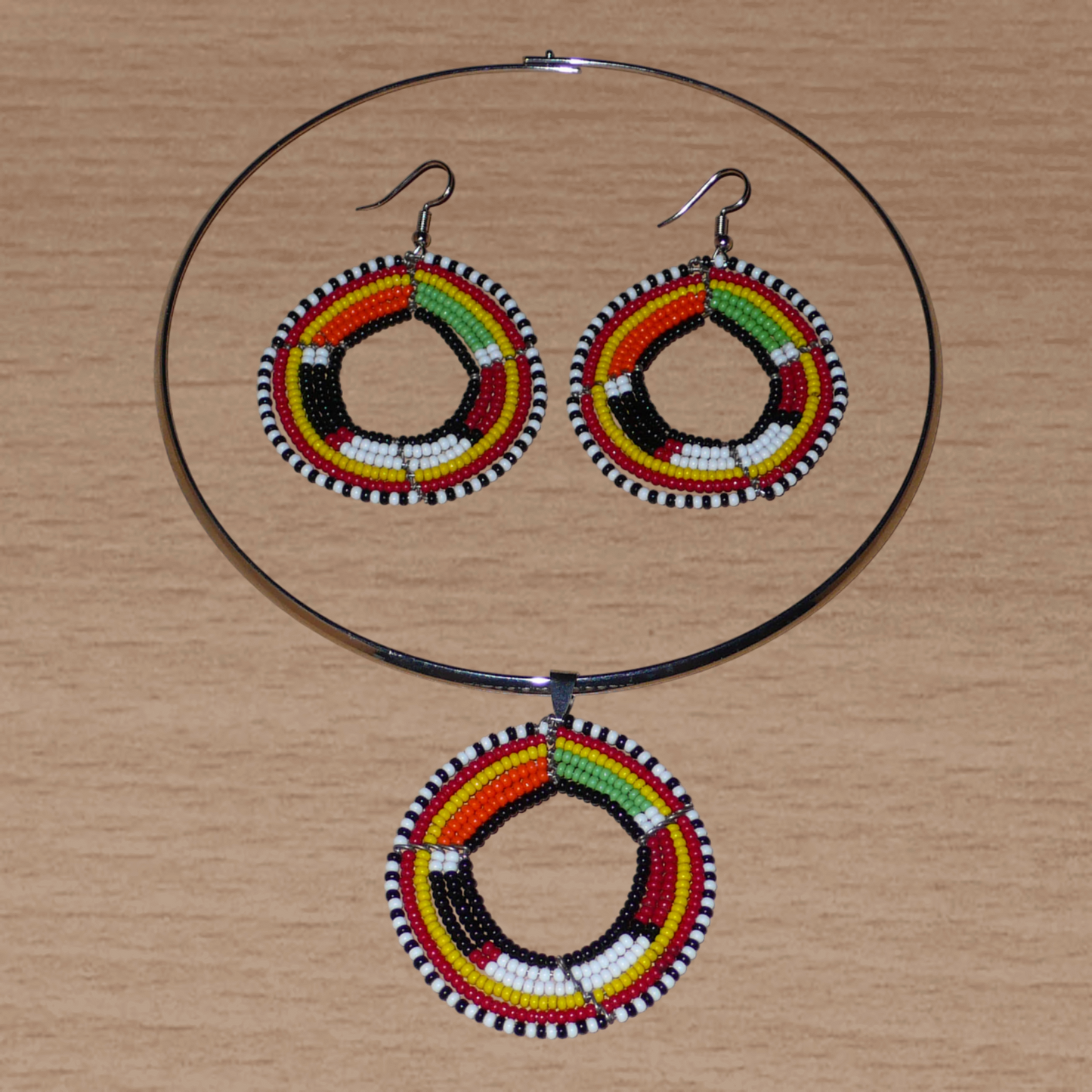 Parure de bijoux africains à motifs ethniques Massai se composant d'un ras-de-cou en laiton orné d'un pendentif rond en perles de rocaille noires et multicolores, et d'une paire de boucles d'oreilles assorties.