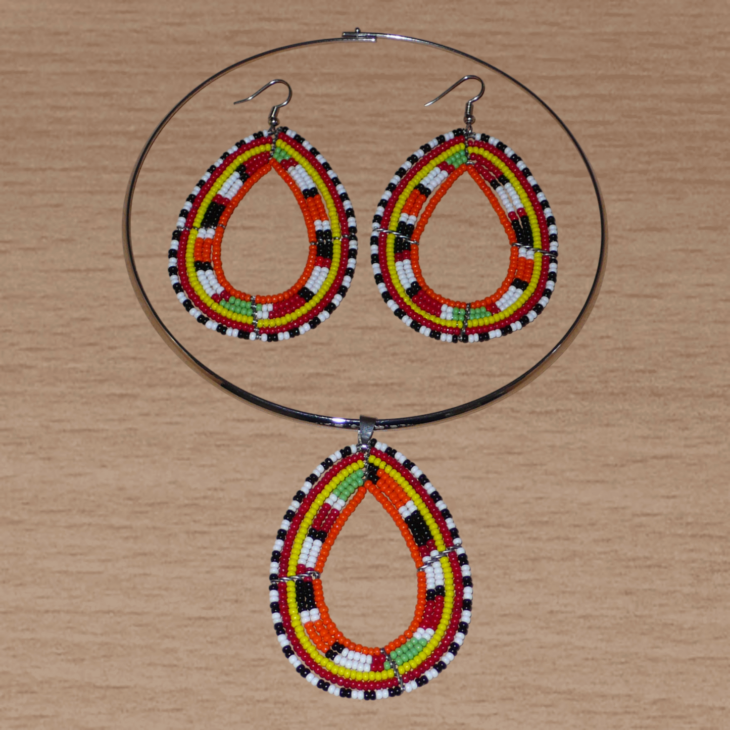 Parure de bijoux africains Massai aux accents afro chic des années 70 ; elle comprend un collier ras-de-cou en laiton rehaussé d'un pendentif aux tons orangés et multicolores, et une paire de longues boucles d'oreilles en forme de gouttes assorties.
