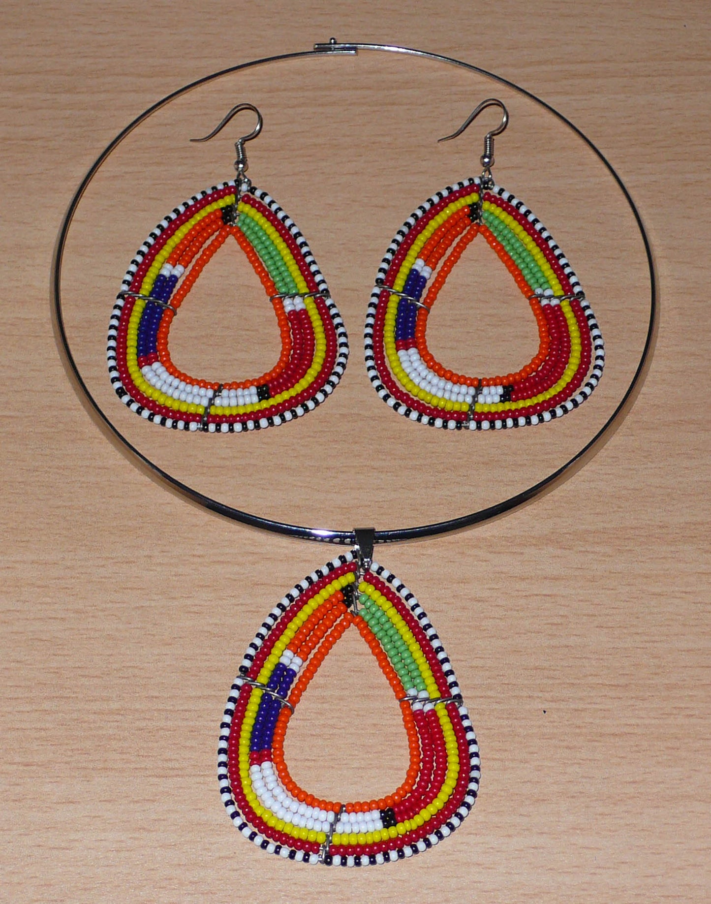 Parure de bijoux africains Massai aux accents afro chic des années 70 comprenant un collier ras-de-cou en laiton orné d'un pendentif de forme triangulaire fait de perles de rocaille orange et multicolores, et une paire boucles d'oreilles assorties.