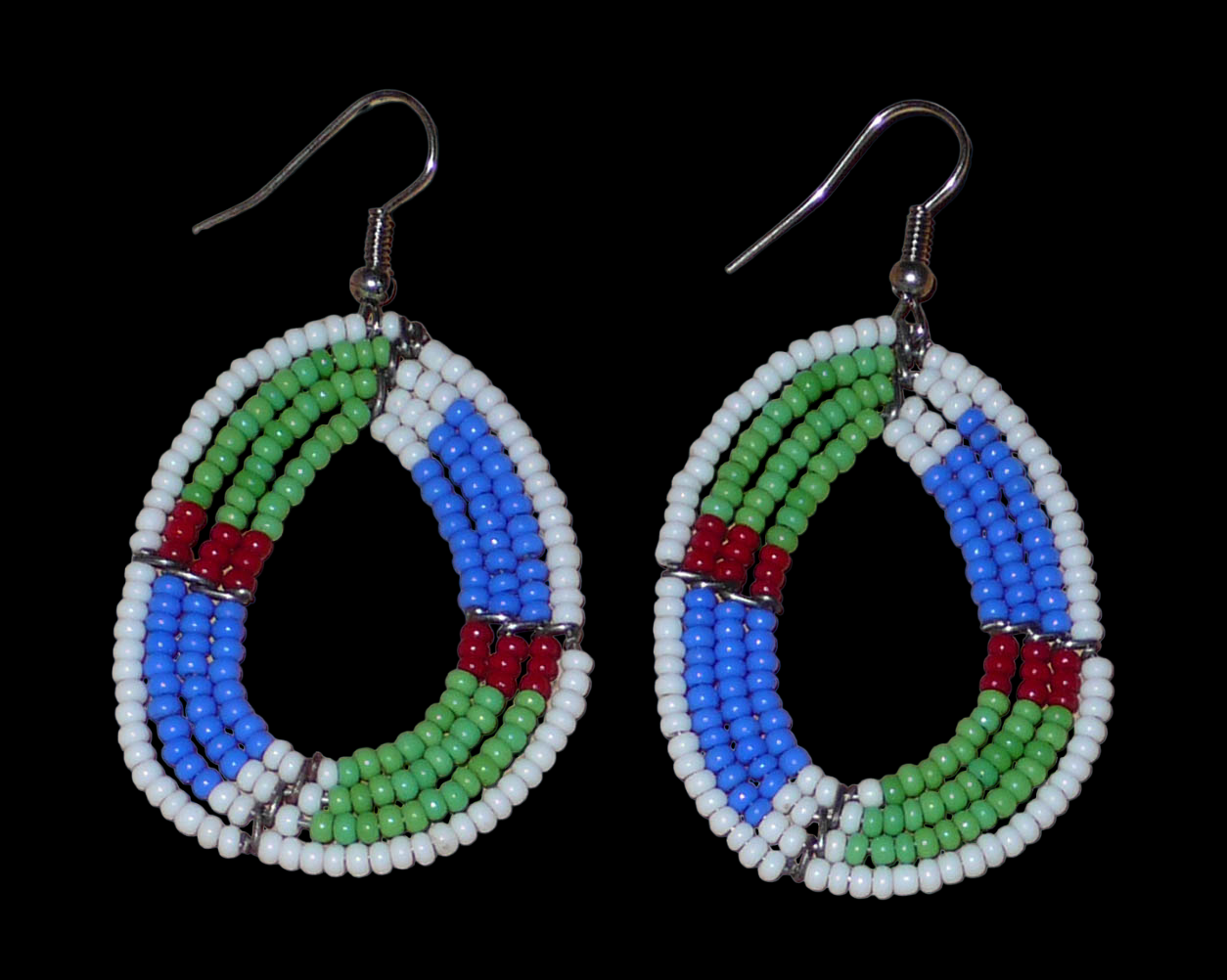 Boucles d'oreilles africaines Massai en forme de gouttes composées de perles de rocaille vertes, bleues, rouges et blanches. Elles mesurent 6 cm de long et 3,5 cm de large et se portent avec des crochets en acier inoxydable sur des oreilles percées.