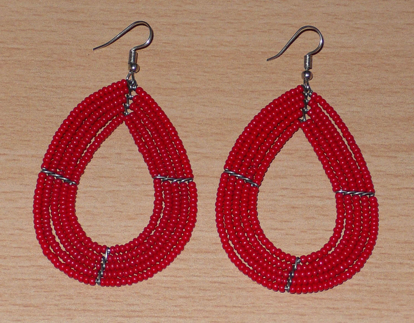 Boucles d'oreilles multi-rangs en forme de gouttes composées de perles de rocaille rouges.