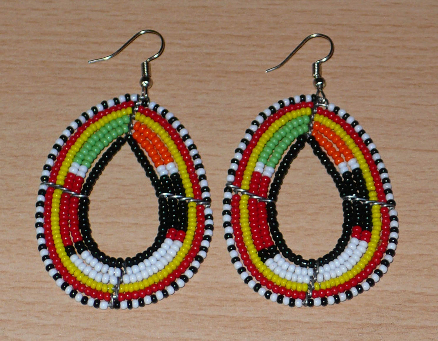 Boucles d'oreilles ethniques Massai en forme de gouttes faites de perles de rocaille multicolores. Elles mesurent 7.5 cm de long et 4 cm de large.