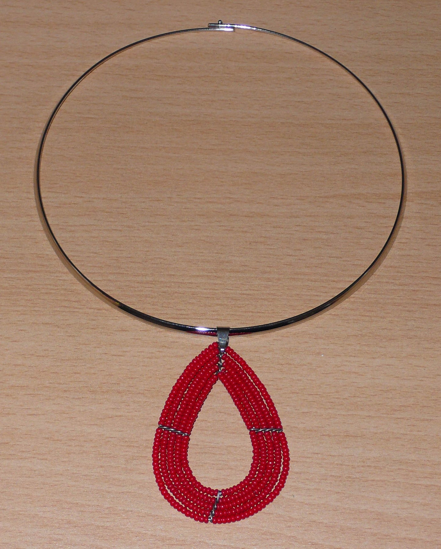 Collier contemporain rouge en laiton orné d'un pendentif multi-rangs perlé en forme de goutte.