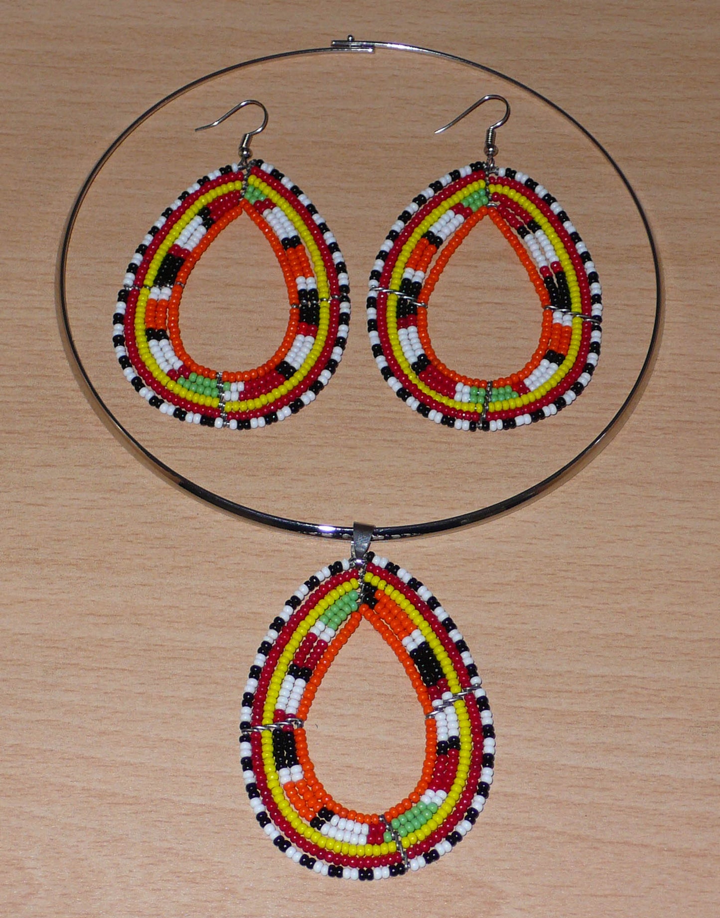 Parure de bijoux africains Massai aux accents afro chic des années 70 ; elle comprend un collier ras-de-cou en laiton rehaussé d'un pendentif aux tons orangés et multicolores, et une paire de longues boucles d'oreilles en forme de gouttes assorties.