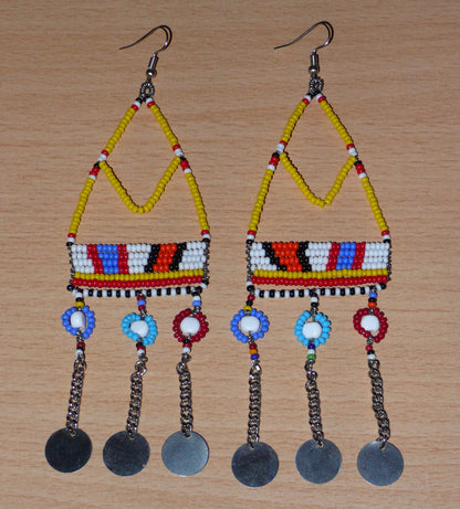 Authentiques boucles d'oreilles africaines Massai jaunes et multicolores composées de perles de rocaille, de perles en plastique et de disques métalliques. Elles mesurent 15 cm de long et se portent sur des oreilles percées.