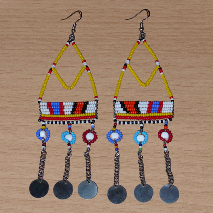 Authentiques boucles d'oreilles africaines Massai jaunes et multicolores composées de perles de rocaille, de perles en plastique et de disques métalliques. Elles mesurent 15 cm de long et se portent sur des oreilles percées.