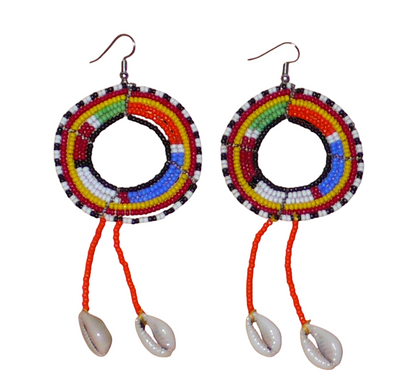Longues boucles d'oreilles africaines Massai rondes à franges perlées, composées de perles de rocaille orange et multicolores et de coquillages cauris. Elles mesurent 12 cm de long et 5 cm de large, et se portent sur des oreilles percées.