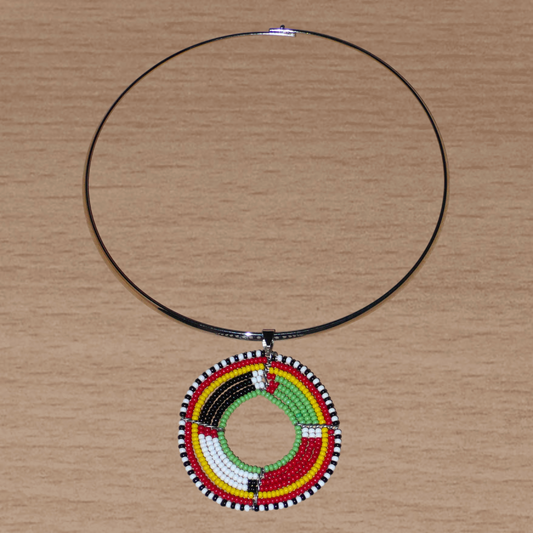 Bijou africain composé d'un collier ras de cou en laiton orné d'un médaillon Massai fait de perles de rocaille rouges, vertes, jaunes, blanches et noires enfilées sur sept rangées de fils de fer montés en cercles. Il mesure 19 cm de long, la circonférence du ras de cou en laiton est de 42,5 cm et 13,5 cm de diamètre ; le pendentif mesure 5,5 cm de long et de large.
