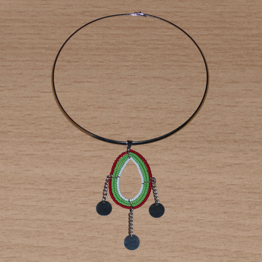 Bijou ethnique chic composé d'un collier ras de cou en laiton agrémenté d'un pendentif tricolore en forme de goutte fait de perles de rocaille vertes, rouges et blanches ; il se prolonge de trois chaînettes ornées de pastilles métalliques.
