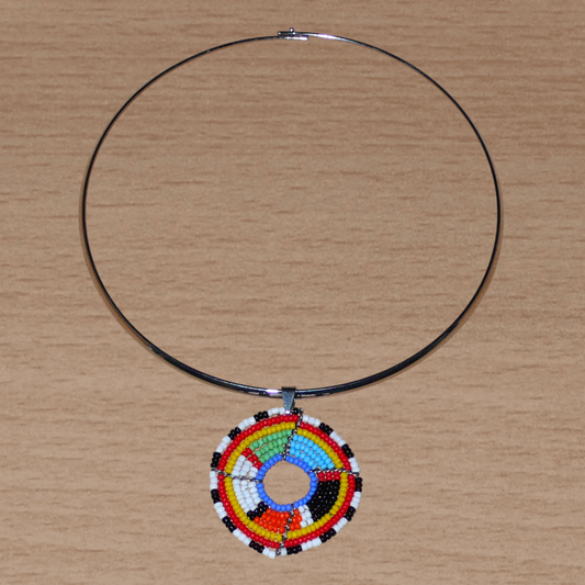 Bijou africain contemporain composé d'un ras de cou en laiton orné d'un médaillon à motifs ethniques Massai fait d'un tissage de perles multicolores.
