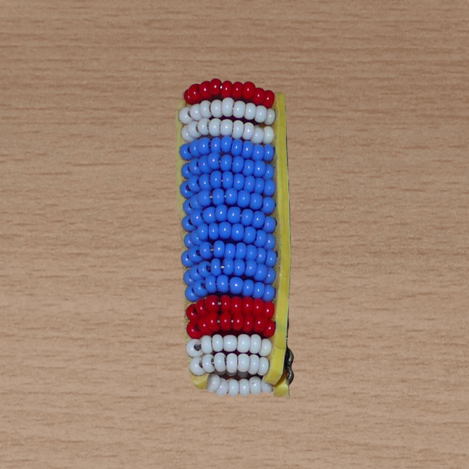 Bijou de locs Massai en perles de rocaille bleues, rouges et blanches.