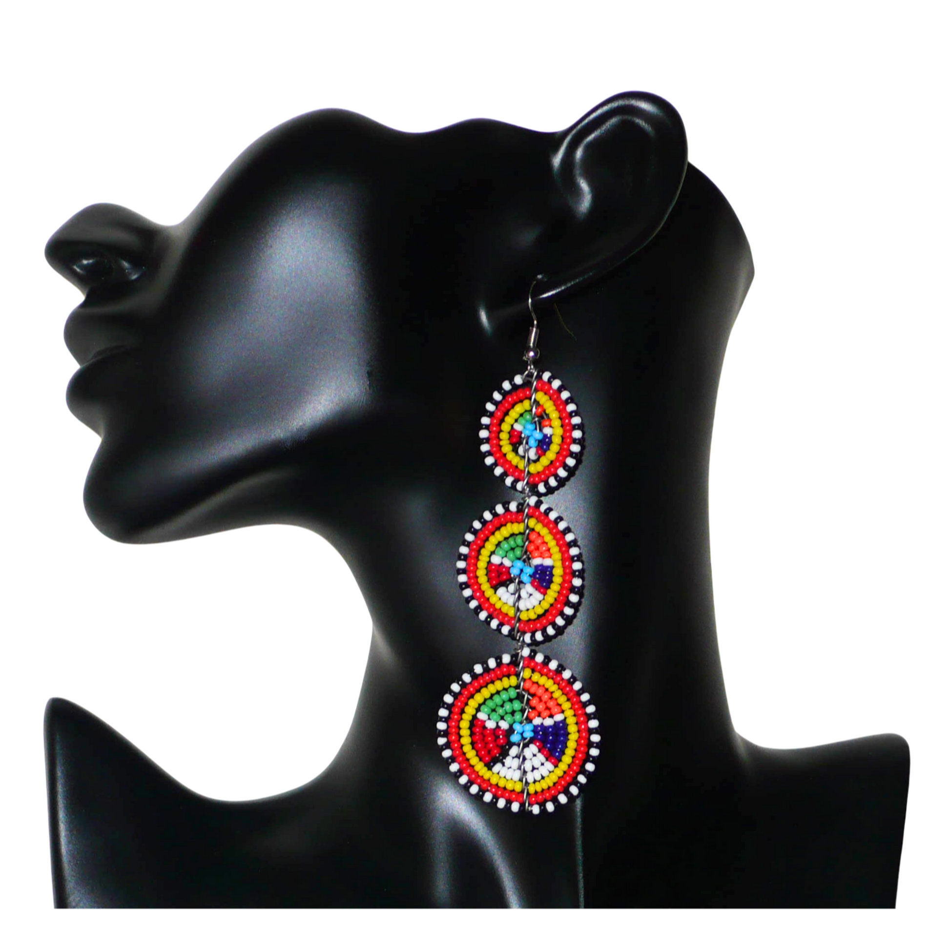 Ajoutez une touche colorée à votre look, évocatrice du style afro chic des années 70, avec ces boucles d'oreilles africaines traditionnelles de confection artisanale Massai. Elles se composent de perles de rocaille multicolores glissées sur des fils de fer montés en forme de trois cercles superposés. Ces boucles d'oreilles mesurent 10.5 cm de long et 3 cm de large ; elles se portent avec des crochets en acier inoxydable sur des oreilles percées.