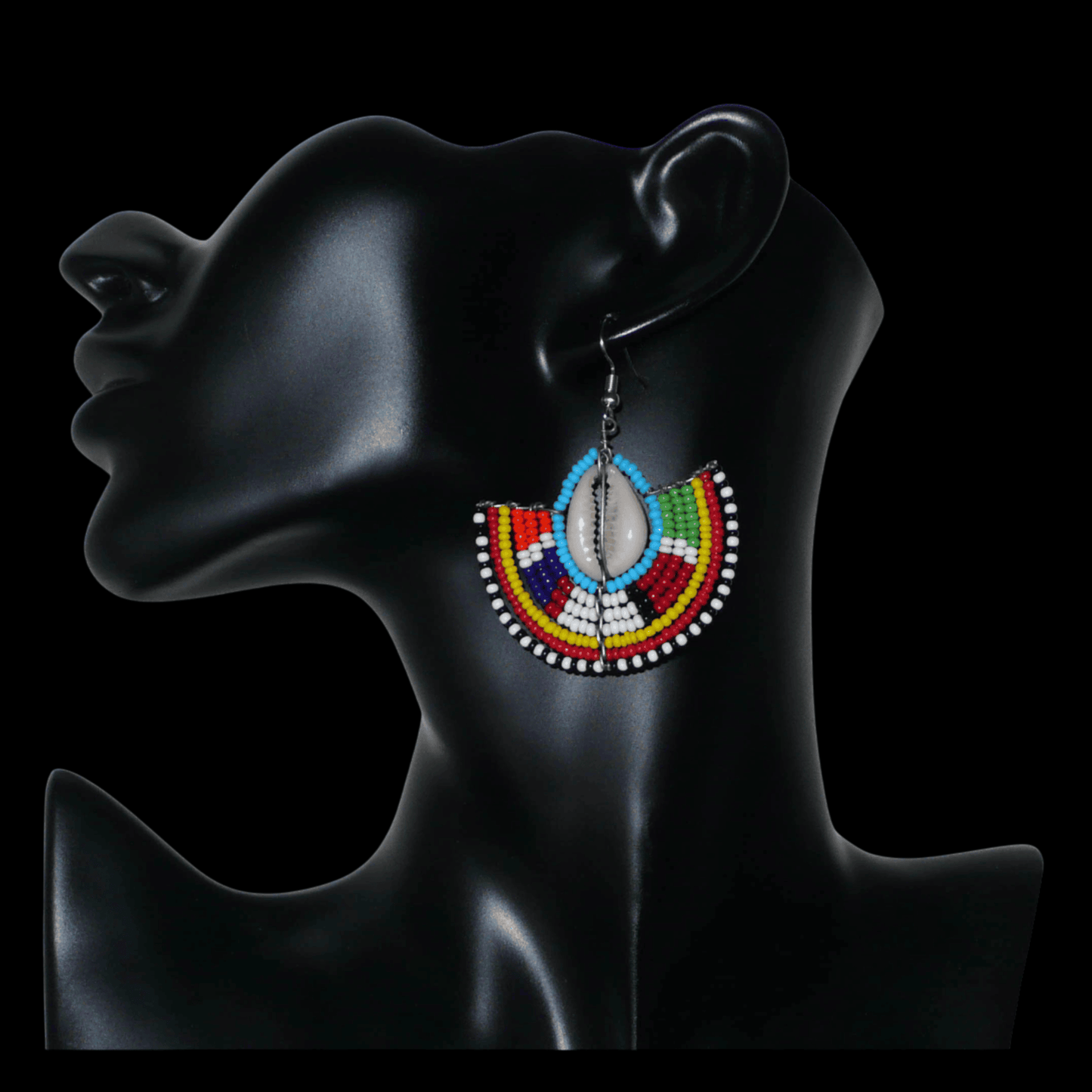 Affirmez votre style et apportez une touche exotique à votre look avec cette paire de boucles d'oreilles africaines Massai issues de l'artisanat traditionnel kenyan. Ces boucles d'oreilles aux accents ethniques chic se composent de perles de rocaille bleues et multicolores et de coquillages cauris. De taille moyenne, elles mesurent 6 cm de long et 4.5 cm de large, et se portent avec des crochets en acier inoxydable sur des oreilles percées.