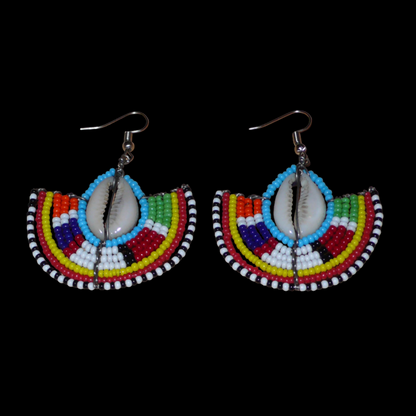 Affirmez votre style et apportez une touche exotique à votre look avec cette paire de boucles d'oreilles africaines Massai issues de l'artisanat traditionnel kenyan. Ces boucles d'oreilles aux accents ethniques chic se composent de perles de rocaille bleues et multicolores et de coquillages cauris. De taille moyenne, elles mesurent 6 cm de long et 4.5 cm de large, et se portent avec des crochets en acier inoxydable sur des oreilles percées.