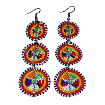 Affirmez votre style avec ces boucles d'oreilles africaines traditionnelles de confection artisanale Massai, évoquant le style afro chic des années 70. Elles se composent de perles de rocaille multicolores enfilées sur des fils de fer montés en forme de trois cercles superposés. Ces boucles d'oreilles mesurent 11 cm de long et 3.5 cm de large ; elles se portent avec des crochets en acier inoxydable sur des oreilles percées.