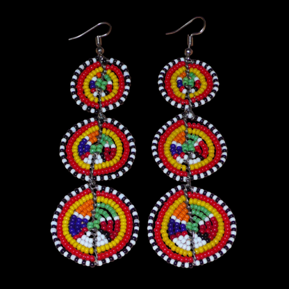 Affirmez votre style avec ces boucles d'oreilles africaines traditionnelles de confection artisanale Massai, évoquant le style afro chic des années 70. Elles se composent de perles de rocaille multicolores enfilées sur des fils de fer montés en forme de trois cercles superposés. Ces boucles d'oreilles mesurent 11 cm de long et 3.5 cm de large ; elles se portent avec des crochets en acier inoxydable sur des oreilles percées.