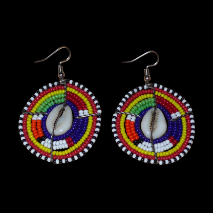 Boucles d'oreilles africaines traditionnelles aux motifs ethniques caractéristiques de l'artisanat Massai. De fabrication kenyane, elles se composent de perles de rocaille bleu foncé et multicolores et de cauris fixés sur des fils de fer montés en forme de boucliers Massai. Ces boucles d'oreilles de taille moyenne mesurent 6 cm de long et 4 cm de large ; elles se portent avec des crochets en acier inoxydable sur des oreilles percées.