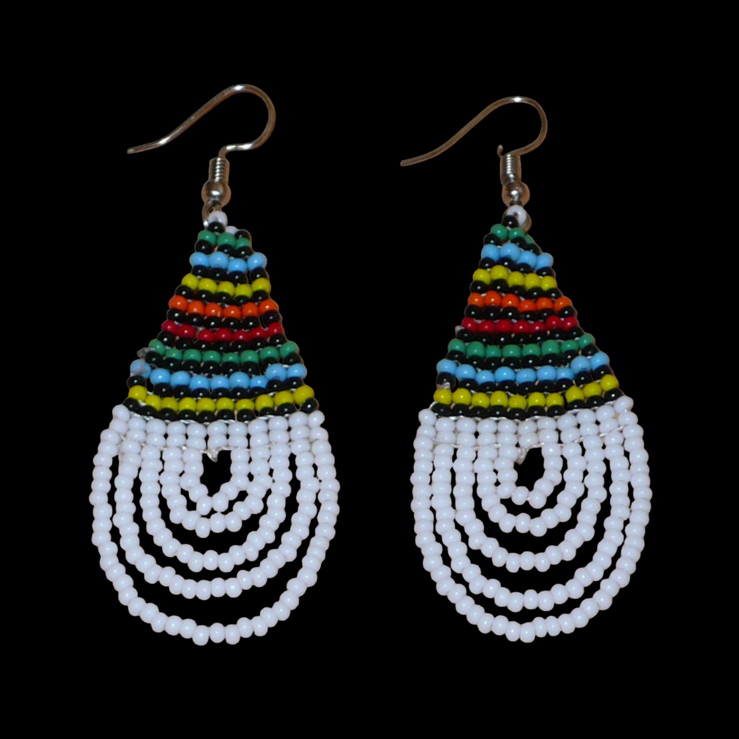 Boucles d'oreilles africaines à motifs traditionnels zoulous en forme de gouttes composées d'un tissage de perles de rocaille blanches et multicolores. Elles mesurent 7 cm de long et 2,5 cm de large et se portent sur des oreilles percées.
