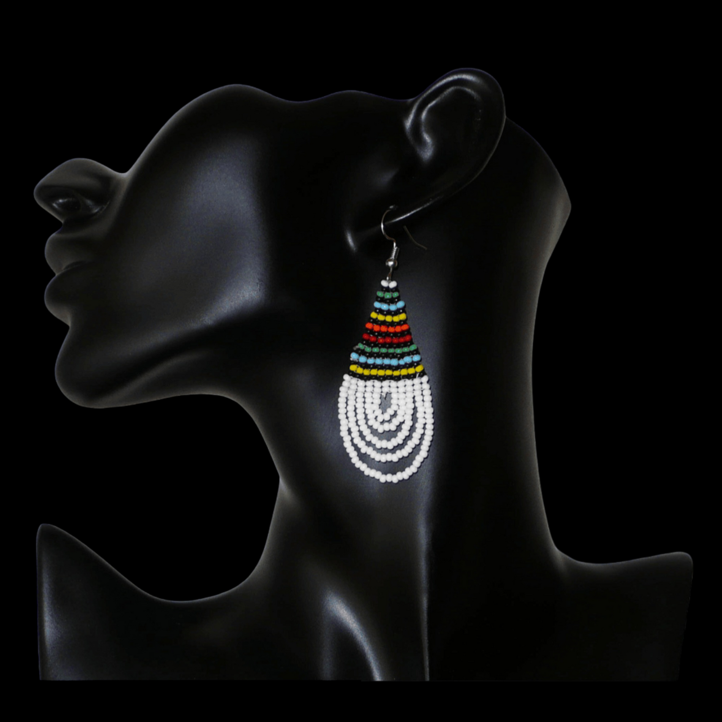 Boucles d'oreilles africaines à motifs traditionnels zoulous en forme de gouttes composées d'un tissage de perles de rocaille blanches et multicolores. Elles mesurent 7 cm de long et 2,5 cm de large et se portent sur des oreilles percées.