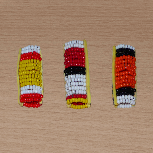 Lot de trois bijoux africains Massai pour dreadlocks fabriqués au Kenya. Ils se composent de perles de rocaille et se portent sur des locs fins ou de taille moyenne en les enfilant ou en les clipsant par pression.