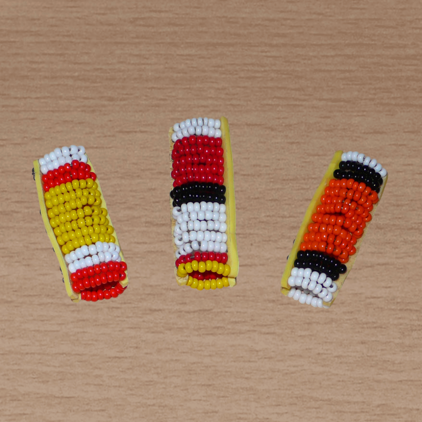 Lot de trois bijoux africains Massai pour dreadlocks fabriqués au Kenya. Ils se composent de perles de rocaille et se portent sur des locs fins ou de taille moyenne en les enfilant ou en les clipsant par pression.