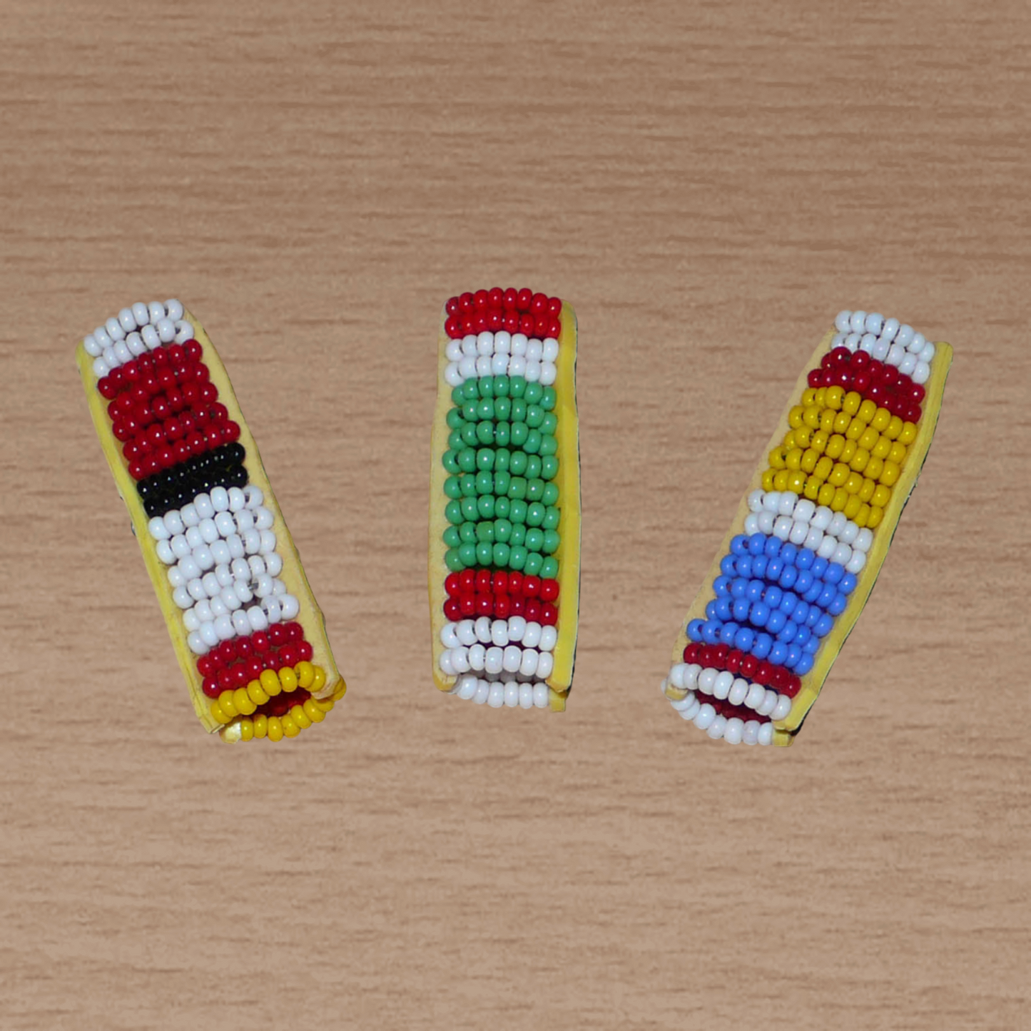Lot de trois bijoux de locs composés de perles de rocaille multicolores à motifs Massai. Ils se portent sur des dreadlocks fins ou de taille moyenne soit en les enfilant, soit en les clipsant par pression.
