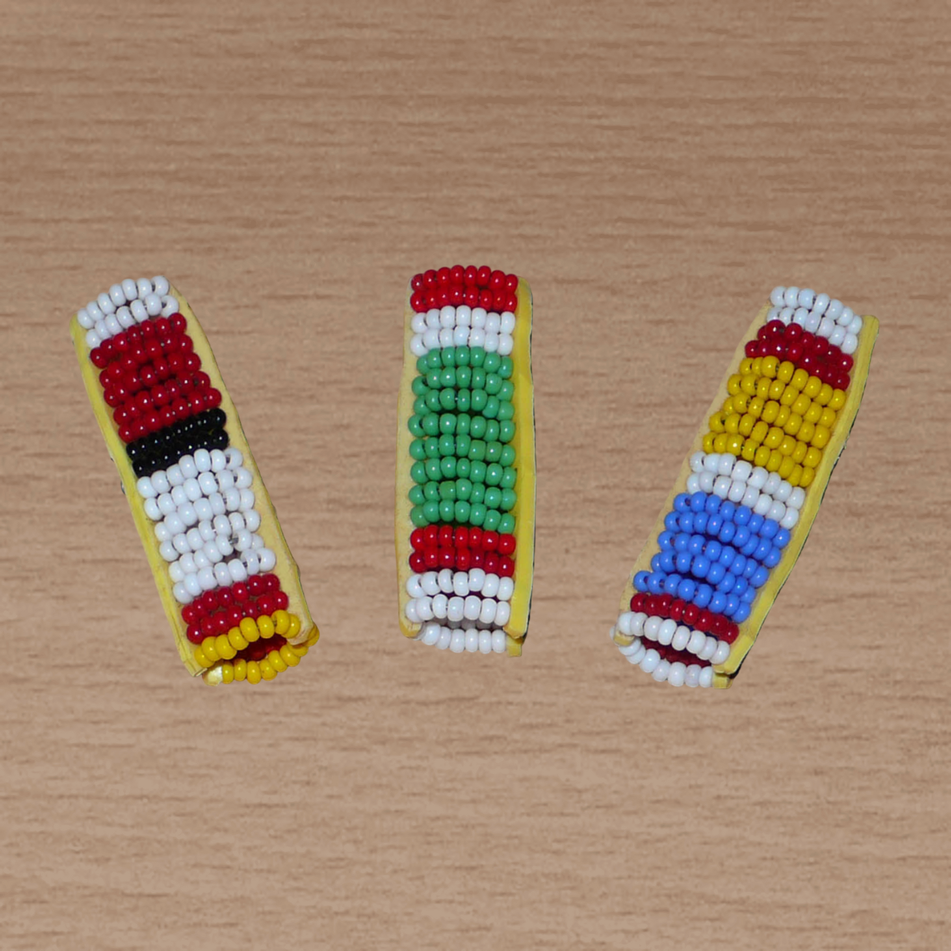 Lot de trois bijoux de locs composés de perles de rocaille multicolores à motifs Massai. Ils se portent sur des dreadlocks fins ou de taille moyenne soit en les enfilant, soit en les clipsant par pression.