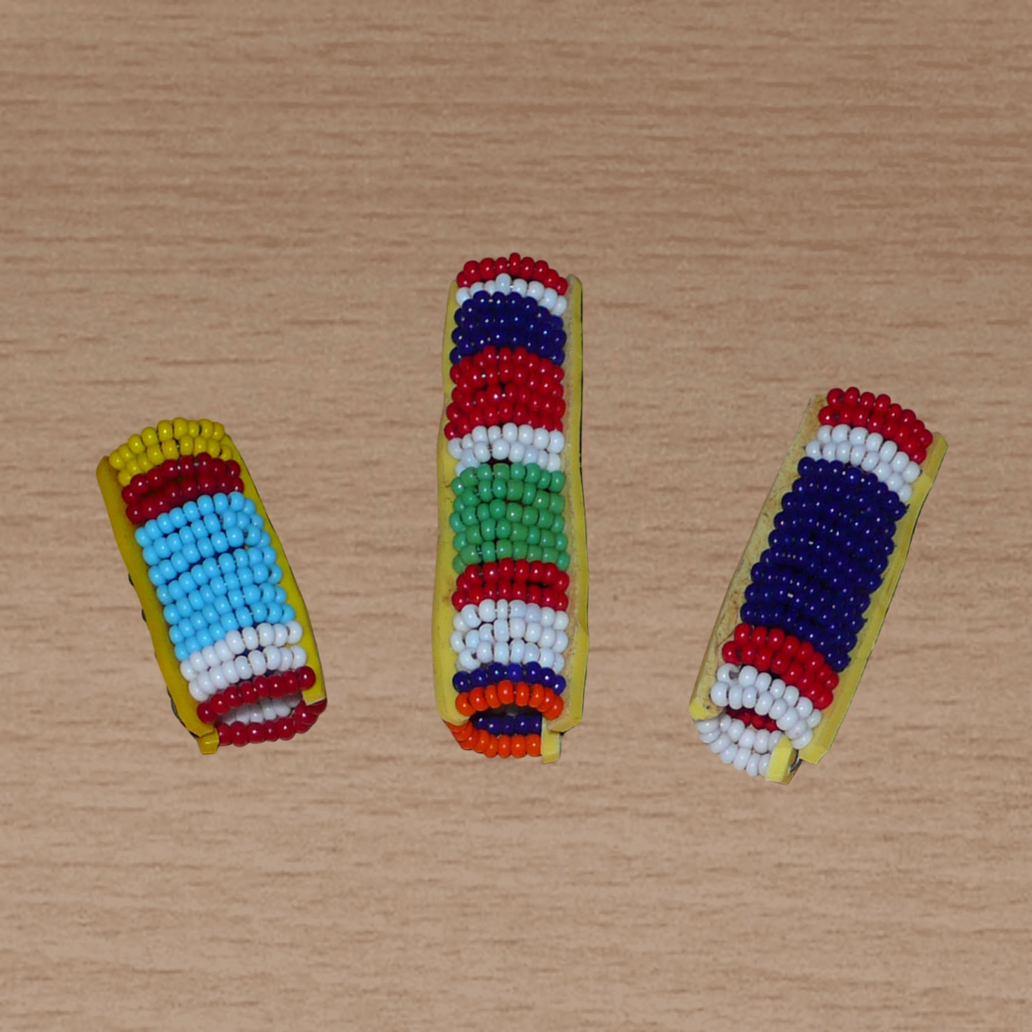 Lot de trois bijoux de locks africains Massai composés de perles de rocaille multicolores. Ils se portent sur des dreadlocks fins ou de taille moyenne soit en les enfilant, soit en les clipsant par pression.