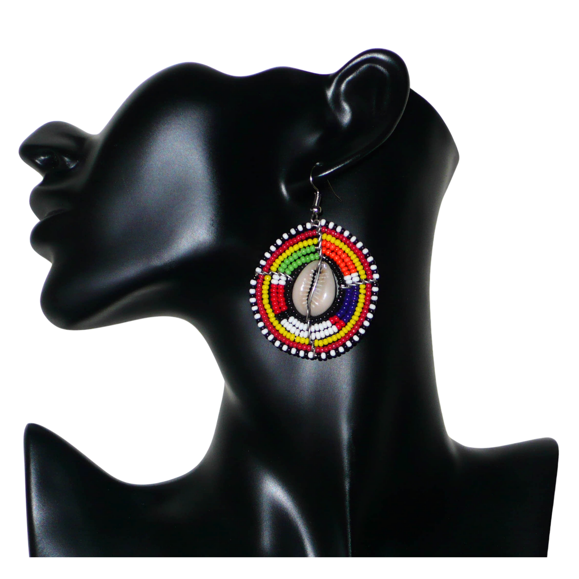 Boucles d'oreilles africaines Massai à motifs ethniques traditionnels : de fabrication artisanale kenyane, elles se composent de perles de rocaille noires et multicolores et de coquillages cauris fixés sur des fils de fer montés en forme de boucliers Massai. De taille moyenne, ces boucles d'oreilles aux accents exotiques mesurent 6.5 cm de long et 4 cm de large ; elles se portent avec des crochets en acier inoxydable sur des oreilles percées.