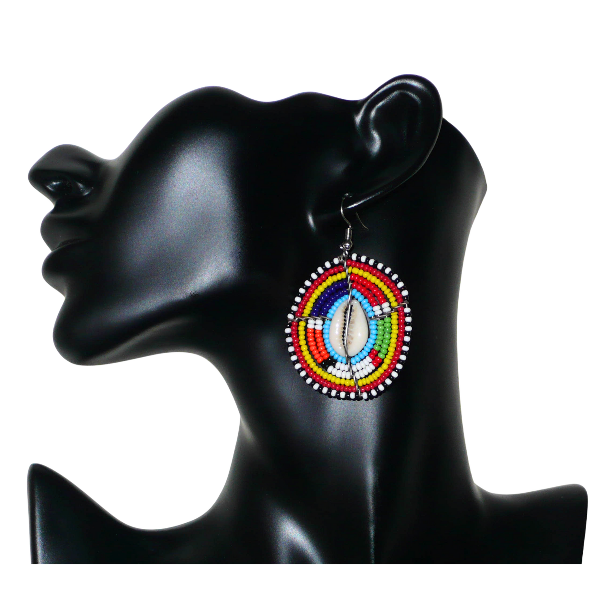 Boucles d'oreilles africaines traditionnelles aux motifs ethniques caractéristiques de l'artisanat Massai. De fabrication kenyane, elles se composent de perles de rocaille bleues et multicolores et de coquillages fixés sur des fils de fer montés en forme de boucliers Massai. Ces boucles d'oreilles de taille moyenne mesurent 6.5 cm de long et 4 cm de large ; elles se portent avec des crochets en acier inoxydable sur des oreilles percées.