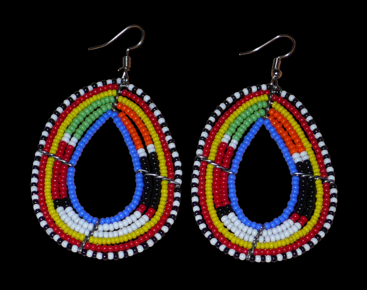 Boucles d'oreilles ethniques multi-rangs à motifs traditionnels Massai composées de perles de rocaille bleues et multicolores glissées sur six rangs de fils de fer montés en forme de gouttes. Elles mesurent 7.5 cm de long et 4 cm de large, et se portent avec des crochets en acier inoxydable sur des oreilles percées.